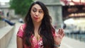 Young Latina woman at Chicago River Walk is having an exciting conversation