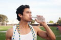 Young latino male athlete drinking water