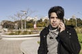 Young Latino man talking on his cell phone in a public park Royalty Free Stock Photo