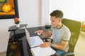 A young Latino who works at home with his laptop, taking orders online