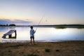 Young Latvian boy fishing in Juglas lake at sunset, Latvian nature, Riga, Latvia, Europe