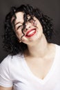 Young laughing girl in a white T-shirt on a black background. Bright brunette with curly hair. Close-up. Royalty Free Stock Photo