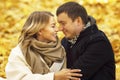 Young laughing man and woman hugging in the autumn park. Romantic couple on a date. Love and tenderness in a relationship. Close- Royalty Free Stock Photo