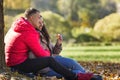 Young laughing man and woman hugging in the autumn park. Romantic couple on a date. Love and tenderness in a relationship. Close- Royalty Free Stock Photo