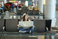 Young laughing traveler tourist woman with crossed legs hold paper map looking aside waiting in lobby hall at Royalty Free Stock Photo