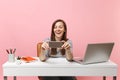 Young laughing woman making video call doing taking selfie shot on mobile phone while sit work at white desk with pc Royalty Free Stock Photo