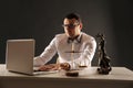 Young laywer sitting and working on a computer. Weight scale and statue of justice. Royalty Free Stock Photo