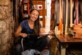 Portrait of a female leather artisan in her workshop with hand-made belt