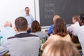 Young lecturer talking to mixed age students