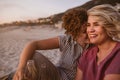 Young lesbian couple having drinks while watching a beach sunset Royalty Free Stock Photo