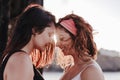 Young lesbian couple hugging at sunset outdoors. Lifestyle and pride concept. love is love