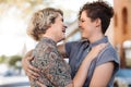 Young lesbian couple laughing while listening to music outside Royalty Free Stock Photo