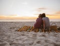 Young lesbian couple sitting on beach blanket watching the sunset Royalty Free Stock Photo