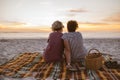 Young lesbian couple watching a romantic sunset at the beach Royalty Free Stock Photo