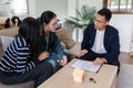 young lesbian married couple discussing agreement with real estate agent or broker. Professional financial advisor or Royalty Free Stock Photo