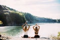 Young lesbian`s couple exercizing yoga at riverside in sunny day