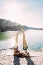 Young lesbian`s couple exercizing yoga at riverside in sunny day