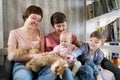A young lesbian same-sex family with two children, a son and a daughter spend time at home. They sit on the couch and Royalty Free Stock Photo