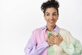 Young lesbian woman holding hand on heart, smiling happy and looking away at logo, being uplifted, pride and lgbtq