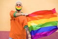 Young lesbian woman with a rainbow mask holding an LGBT flag - Focus on girl`s face Royalty Free Stock Photo