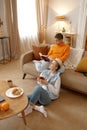 Young lgbt woman couple drinking coffee planning future while resting at home