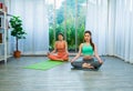 young lgbt women exercise together, sit meditate on yoga mat