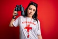 Young lifeguard woman wearing secury guard equipent holding binoculars over red background with a confident expression on smart