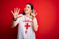 Young lifeguard woman wearing secury guard equipent over red background afraid and terrified with fear expression stop gesture