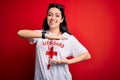 Young lifeguard woman wearing secury guard equipent over red background gesturing with hands showing big and large size sign,