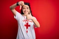 Young lifeguard woman wearing secury guard equipent over red background smiling making frame with hands and fingers with happy