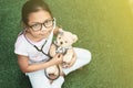 Young little asian girl playing pretend to be a doctor. young girl eaxamine her teddy bear with stethoscope Royalty Free Stock Photo