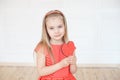 Young little blonde girl wearing in long sleeveless dress holding red cardboard heart Royalty Free Stock Photo