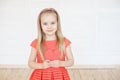 Young little blonde girl wearing in long sleeveless dress holding red cardboard heart Royalty Free Stock Photo