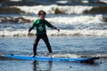 Young little boy on beach taking surfing lessons