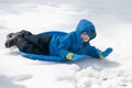 Young little boy enjoying sledding outside on a snow day Royalty Free Stock Photo