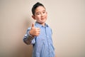 Young little boy kid wearing elegant shirt standing over isolated background doing happy thumbs up gesture with hand Royalty Free Stock Photo