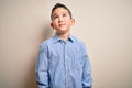 Young little boy kid wearing elegant shirt standing over isolated background smiling looking to the side and staring away thinking Royalty Free Stock Photo