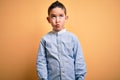 Young little boy kid wearing elegant shirt standing over yellow isolated background making fish face with lips, crazy and comical Royalty Free Stock Photo