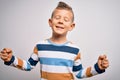 Young little caucasian kid with blue eyes standing wearing striped shirt over isolated background very happy and excited doing Royalty Free Stock Photo