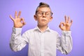 Young little caucasian kid with blue eyes wearing glasses and white shirt over purple background relax and smiling with eyes Royalty Free Stock Photo