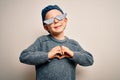 Young little caucasian kid wearing internet meme thug life glasses over isolated background smiling in love showing heart symbol Royalty Free Stock Photo