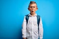 Young little caucasian student kid wearing smart glasses and school bag over blue background afraid and shocked with surprise Royalty Free Stock Photo