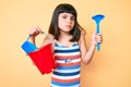 Young little girl with bang playing with summer shovel and bucket toys clueless and confused expression