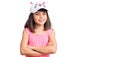 Young little girl with bang wearing funny kitty cap happy face smiling with crossed arms looking at the camera Royalty Free Stock Photo