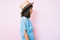 Young little girl with bang wearing summer dress and hat looking to side, relax profile pose with natural face with confident Royalty Free Stock Photo