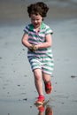 Young little girl on beach playing in the surf Royalty Free Stock Photo