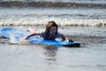 Young little girl on beach taking surfing lessons