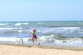 Young Little Girl And Golden Retriever Dog Running On The Beach. Dog And Owner Outdoors. Royalty Free Stock Photo