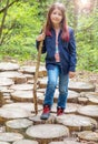 Young little girl hiker walk on the path of cut trees Royalty Free Stock Photo