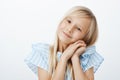 Young little girl making adorable face to get what wants. Pleased caring young child with blond hair, smiling broadly